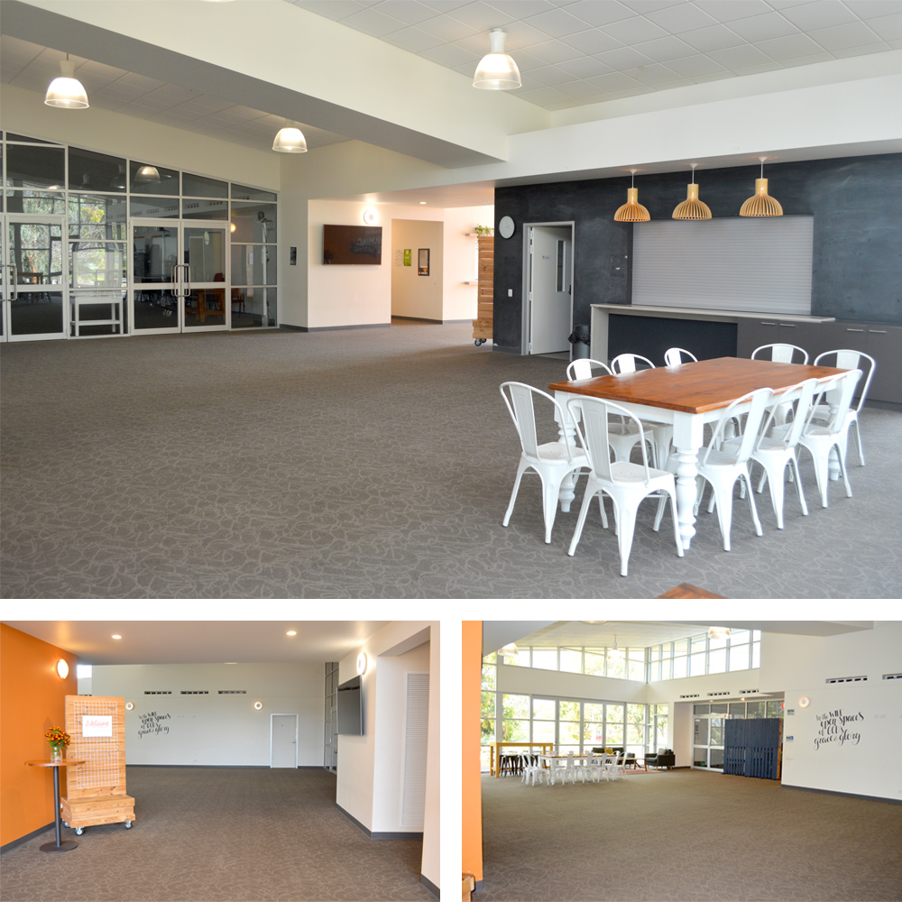 The foyer is a large open space with a wall of windows brining light in. Against the windows there are a couple of couches for comfortable conversation. In the center there is a large table surrounded by many chairs, along with a bar height table and bar stools. 